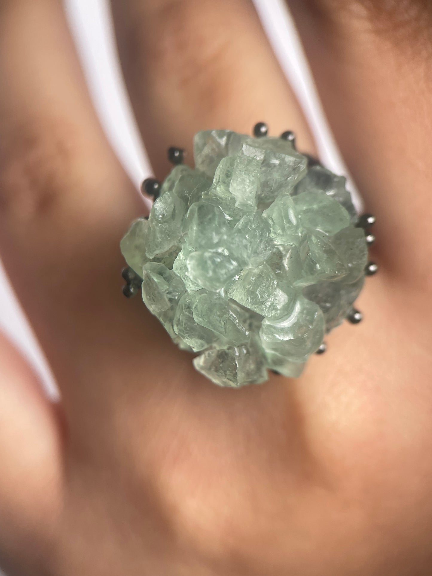 green quartz crystal cluster ring worn on hand close up
