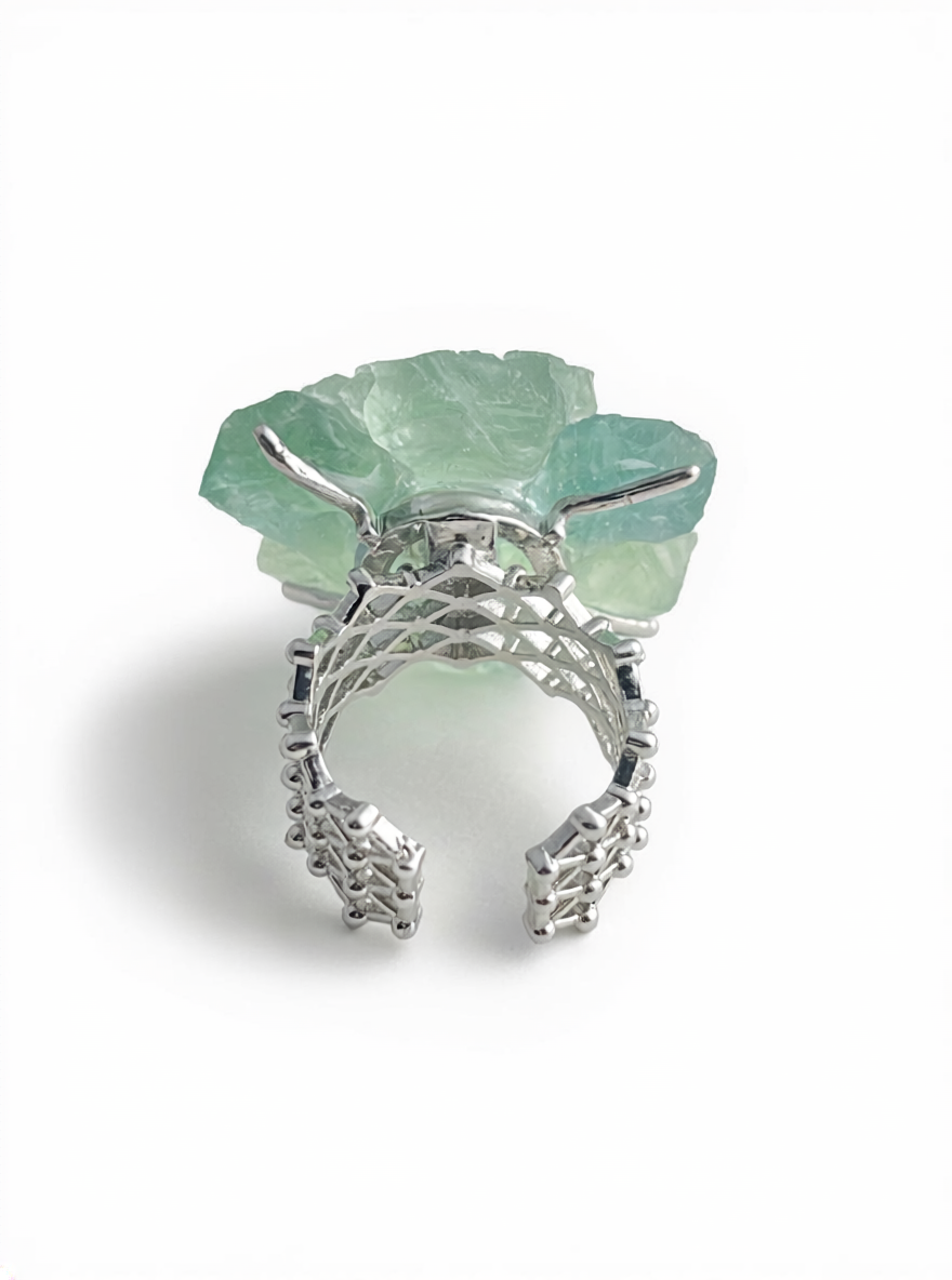 Back view of green quartz flower ring with garnet center and open band