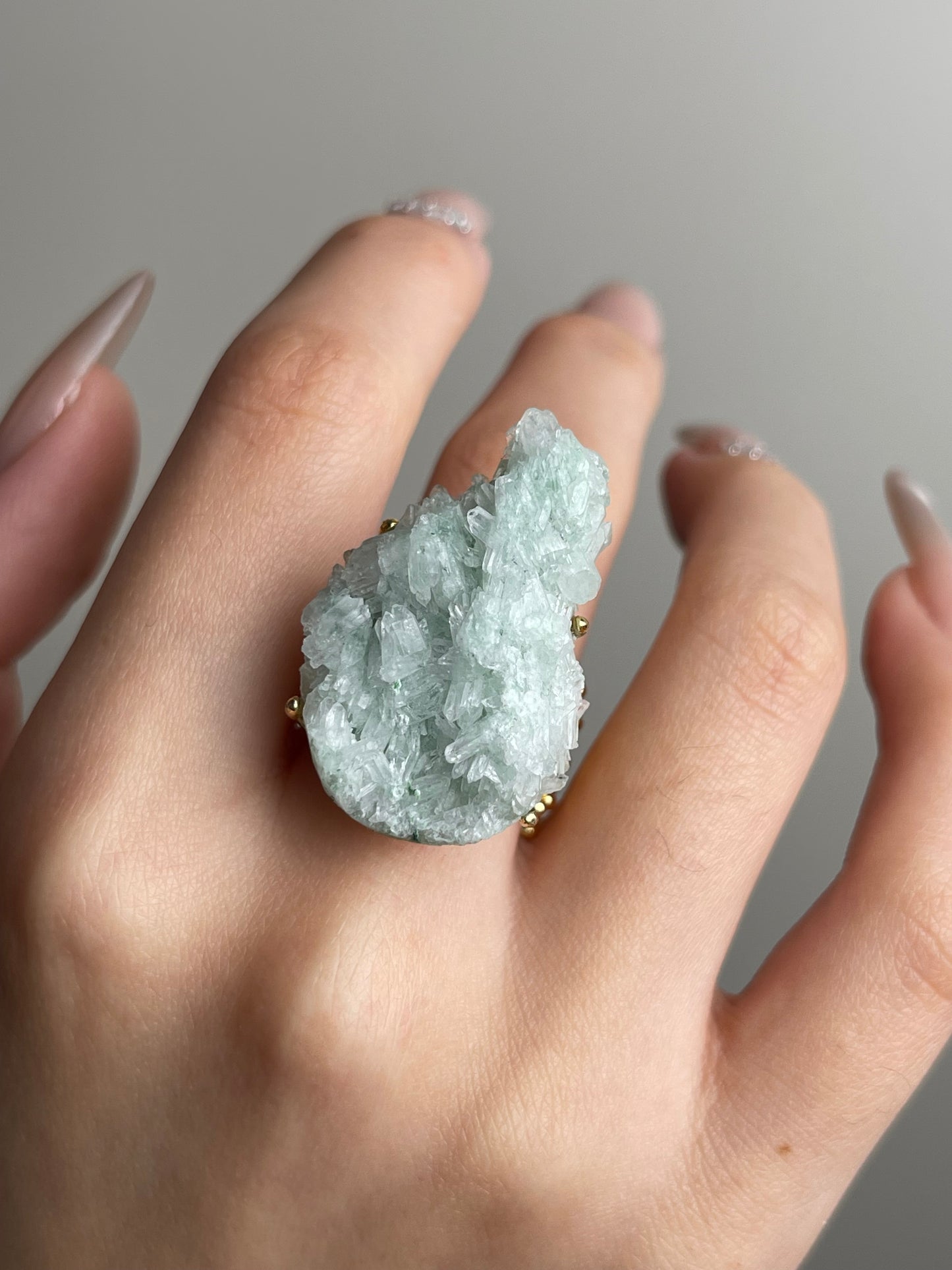 Close-up hand shot of green strawberry quartz ring
