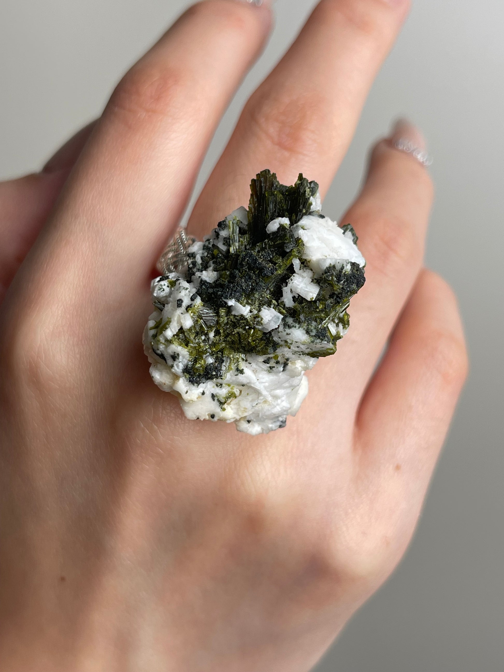 Green tourmaline feldspar mineral specimen hand close up