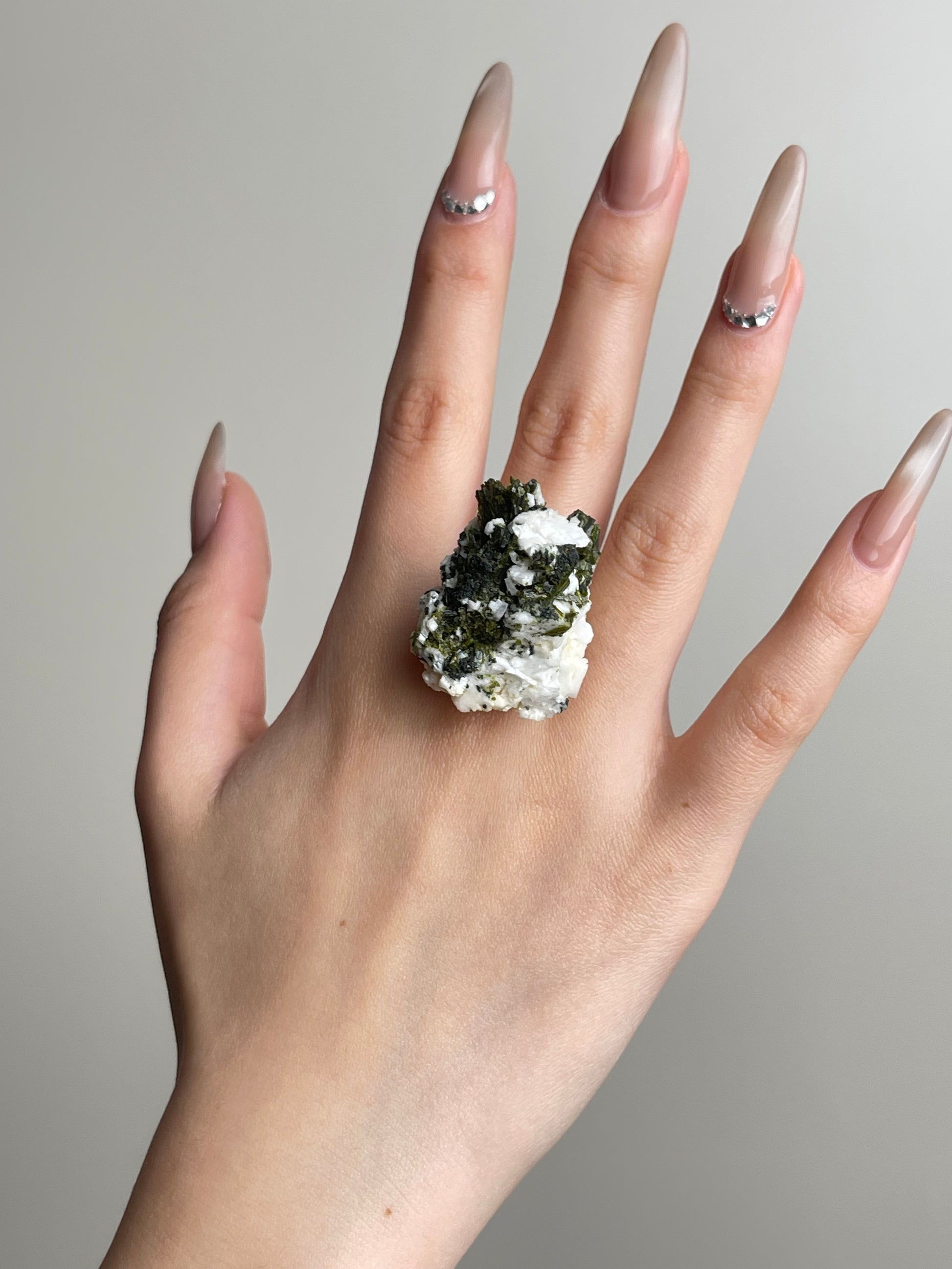 Green tourmaline feldspar mineral specimen held in hand