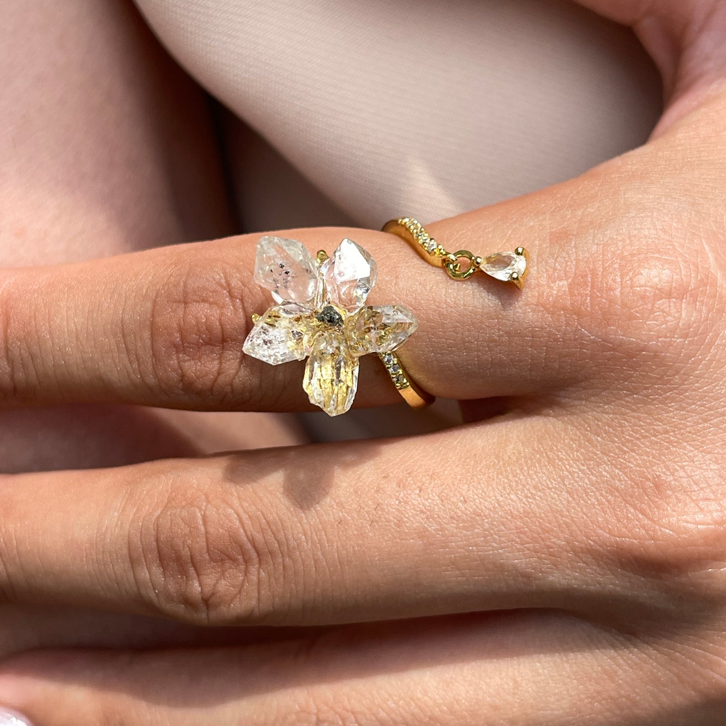 Close up of Hakima Diamond Quartz and Chalcopyrite flower ring on hand
