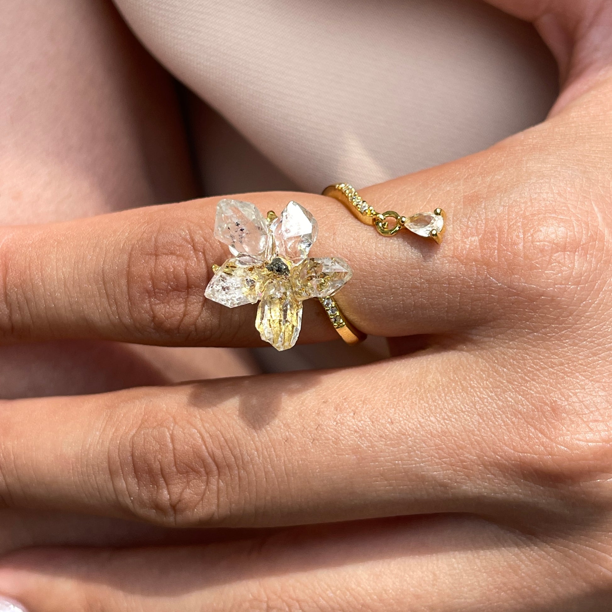 Close up of Hakima Diamond Quartz and Chalcopyrite flower ring on hand
