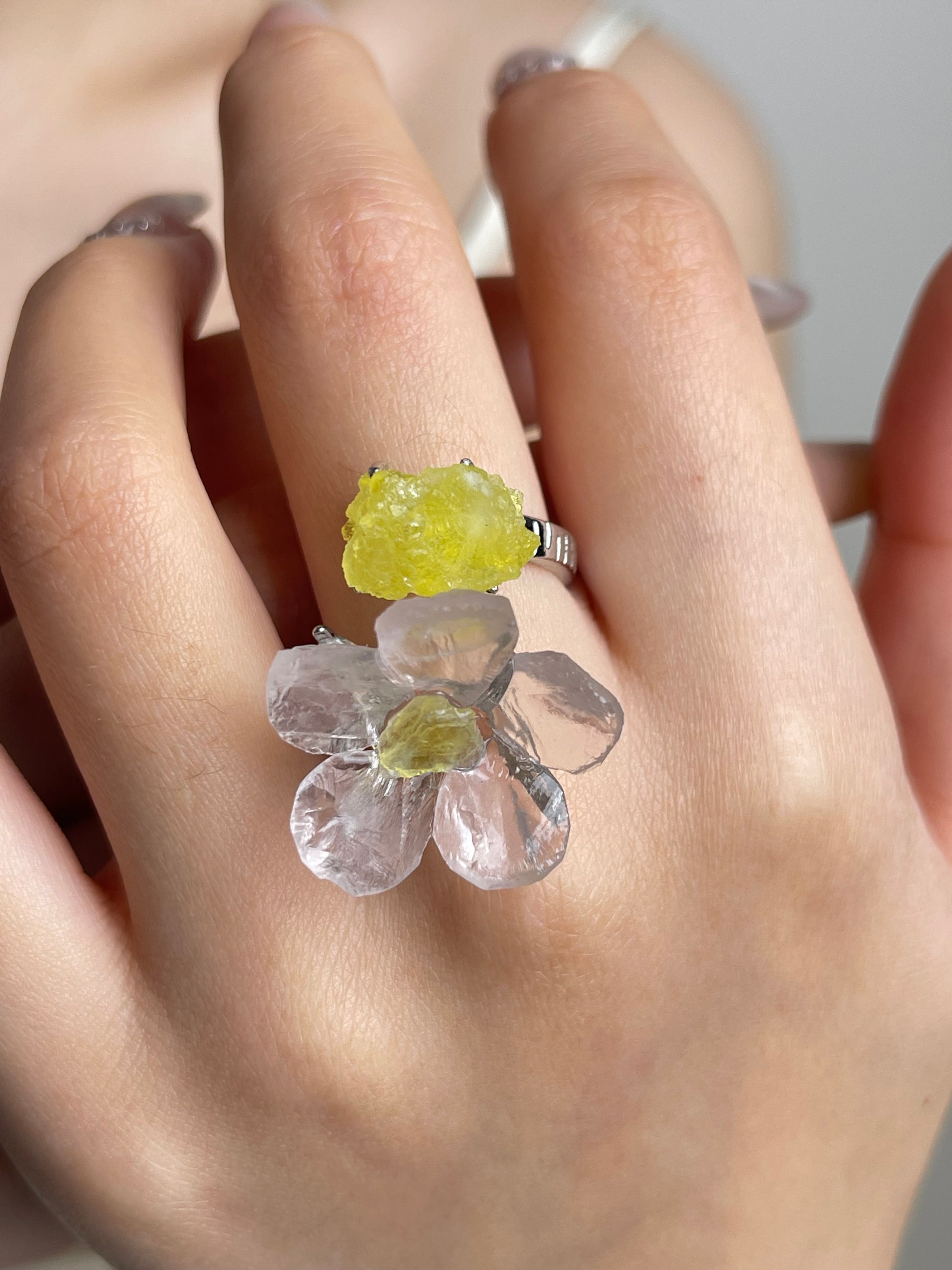 Close-up hand shot of hand-carved Rose Quartz flower ring with Brucite