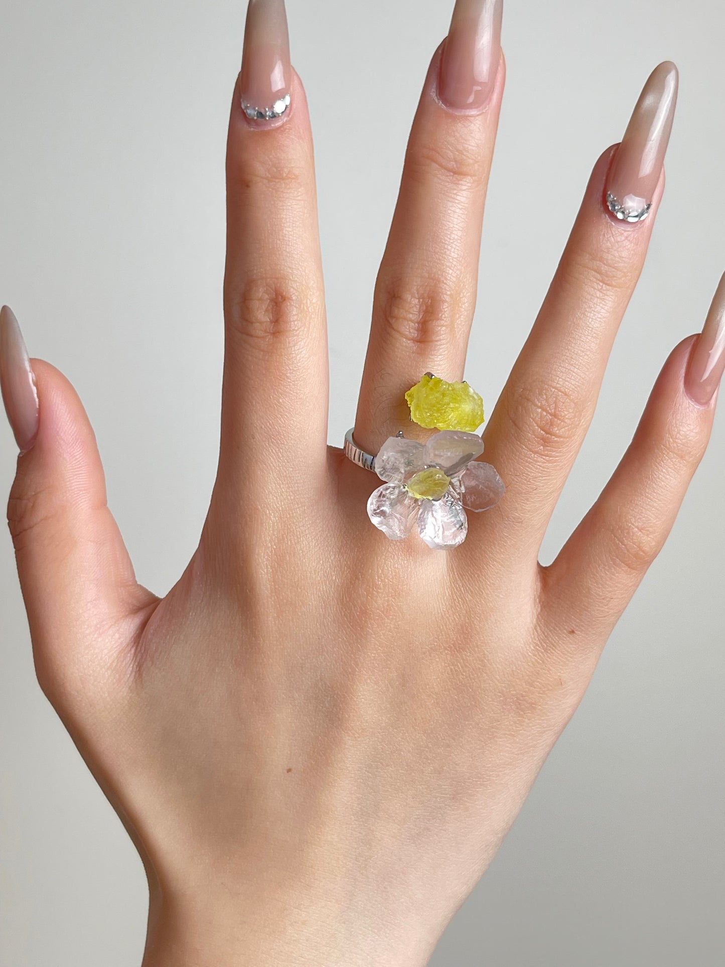 Hand shot of hand-carved Rose Quartz flower ring with Brucite by Oryssia