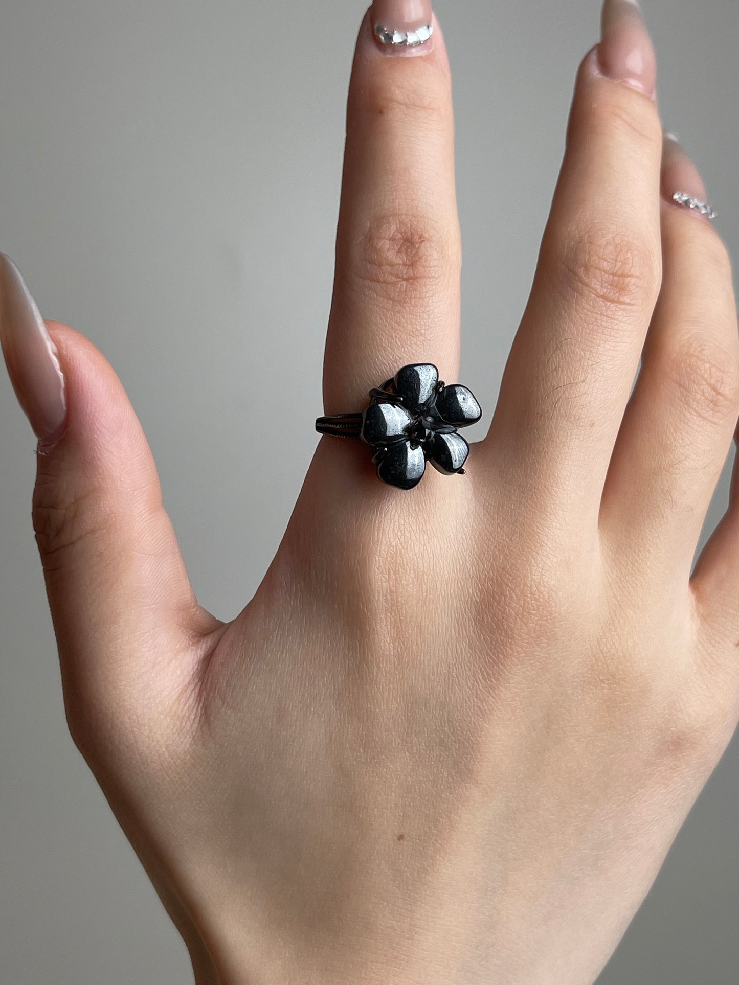 Hand shot of Hematite flower ring with Herkimer Diamond Quartz