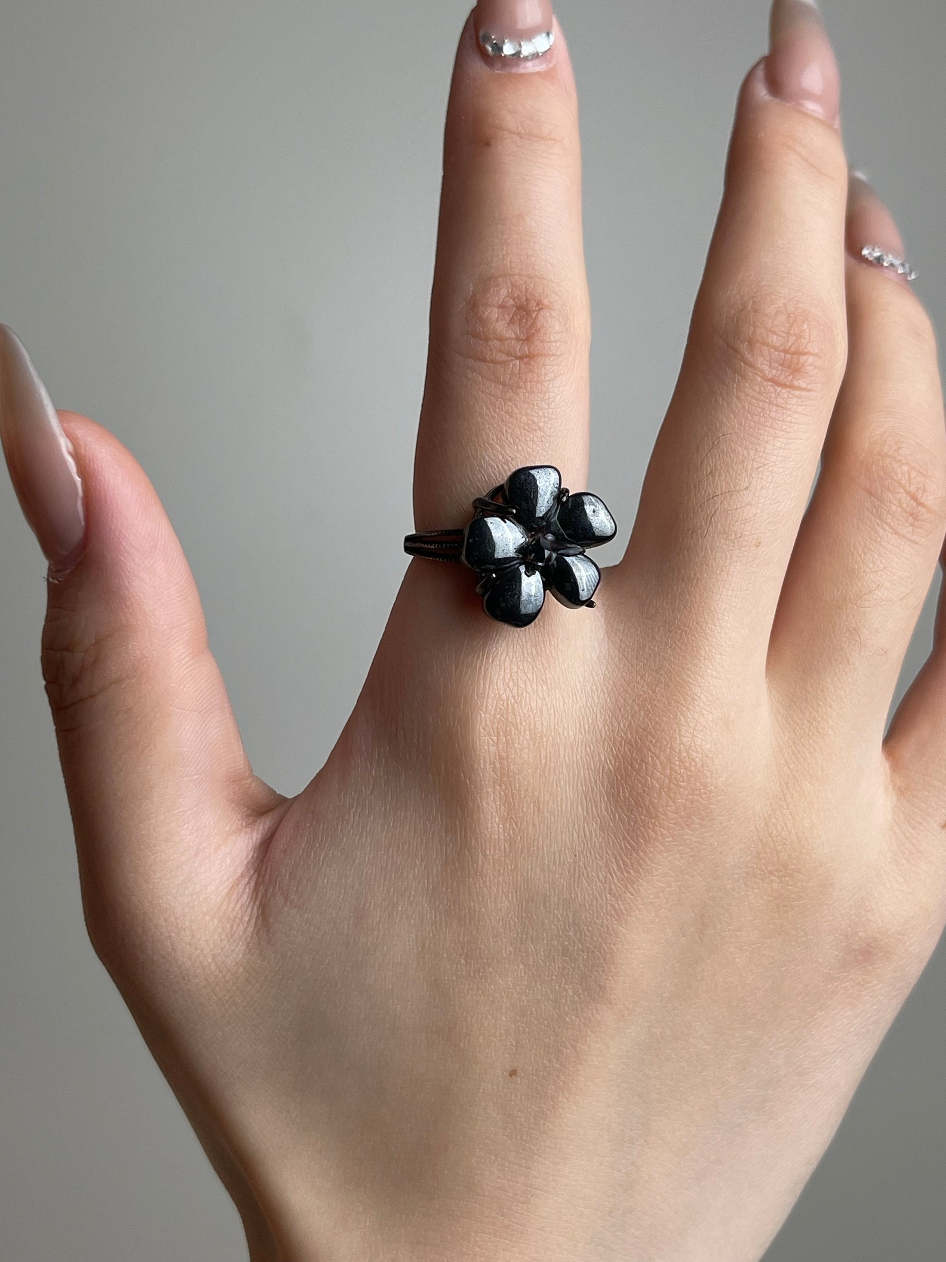 Hand shot of Hematite flower ring with Herkimer Diamond Quartz