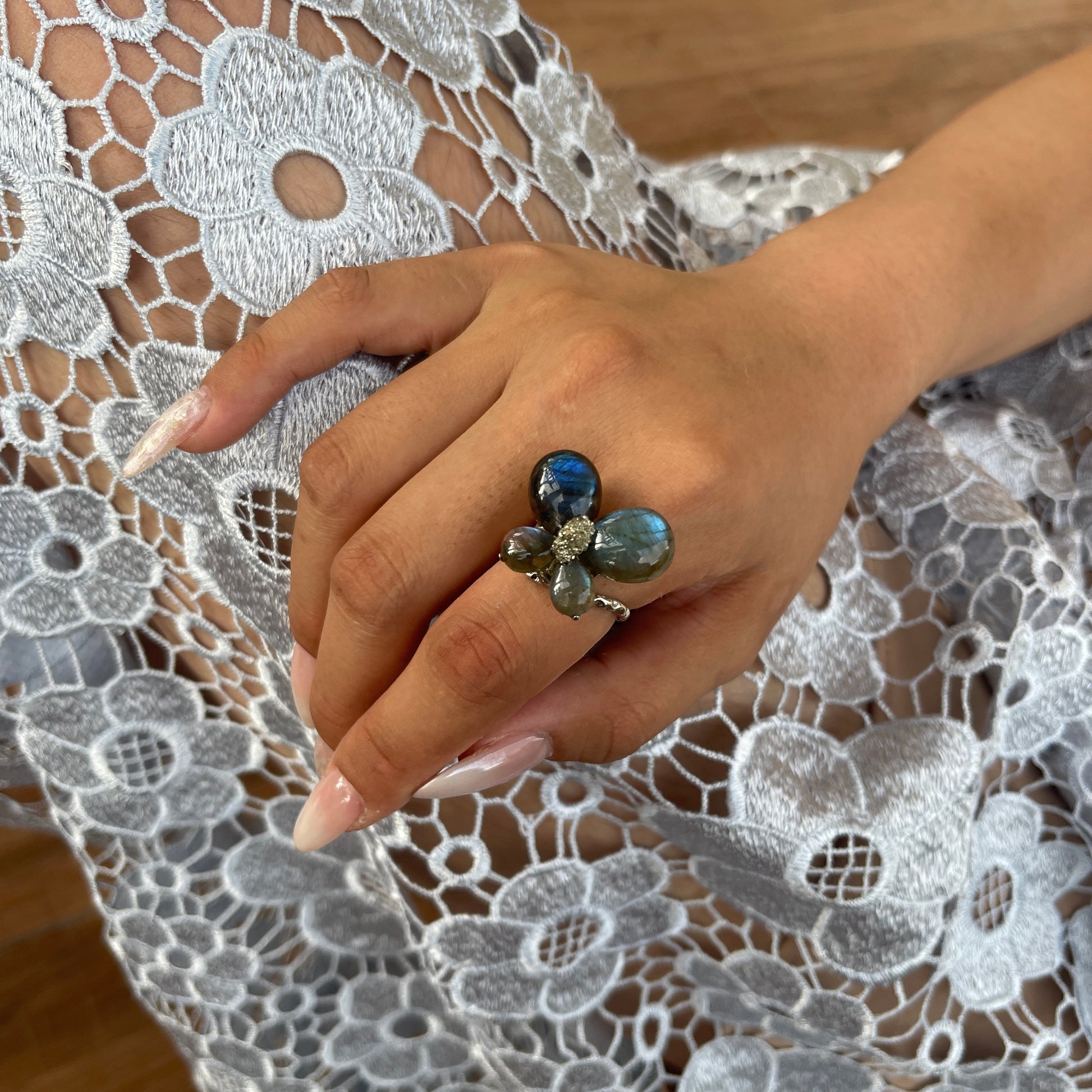 Close-up hand view of Labradorite Butterfly Ring with raw Chalcopyrite