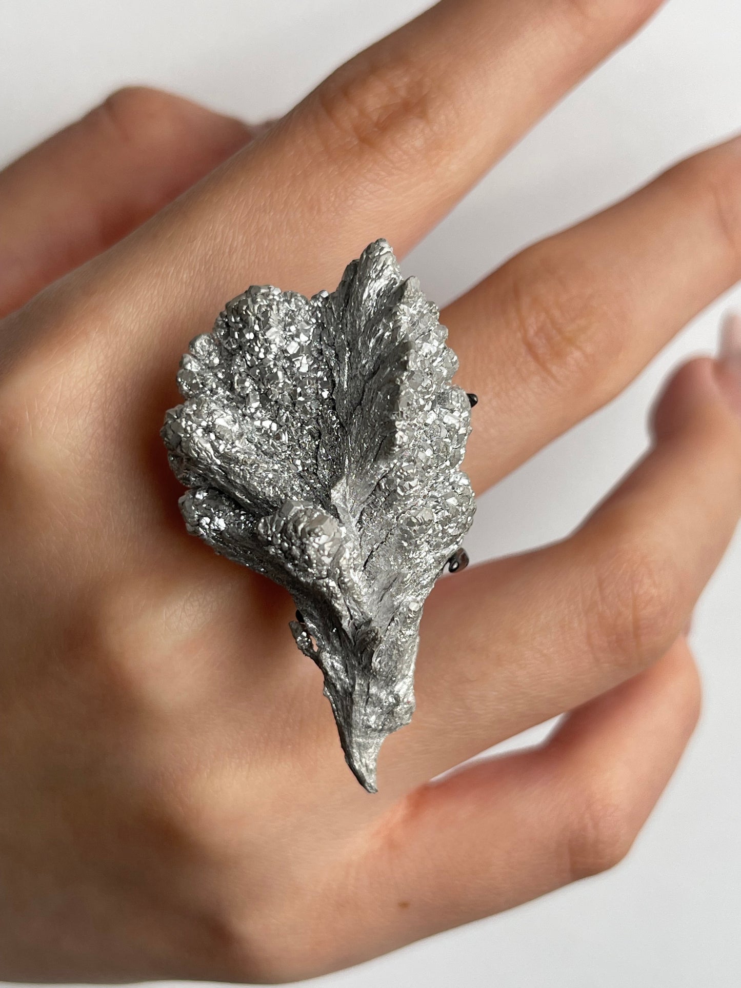 macro magnesium crystal ring worn on hand