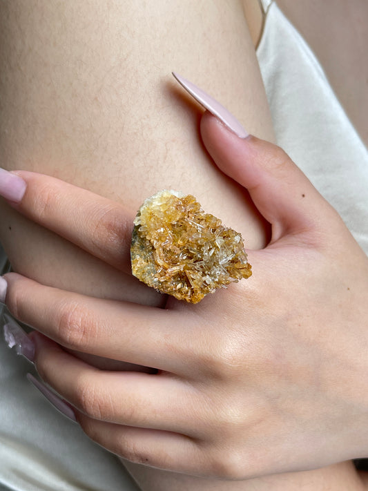 Close-up of needle quartz cluster mineral specimen ring on hand