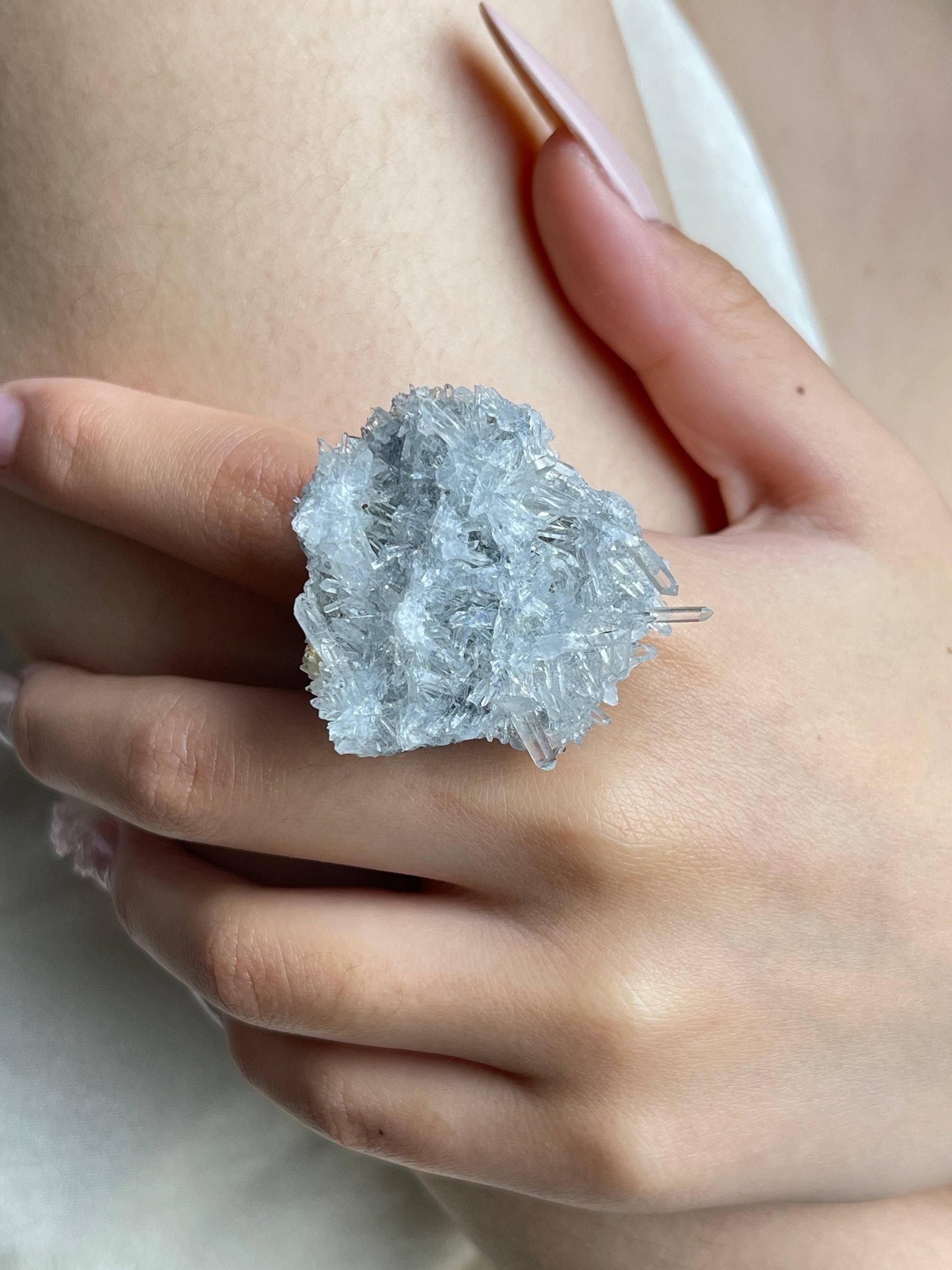 Close-up hand wearing Needle Quartz crystal cluster ring
