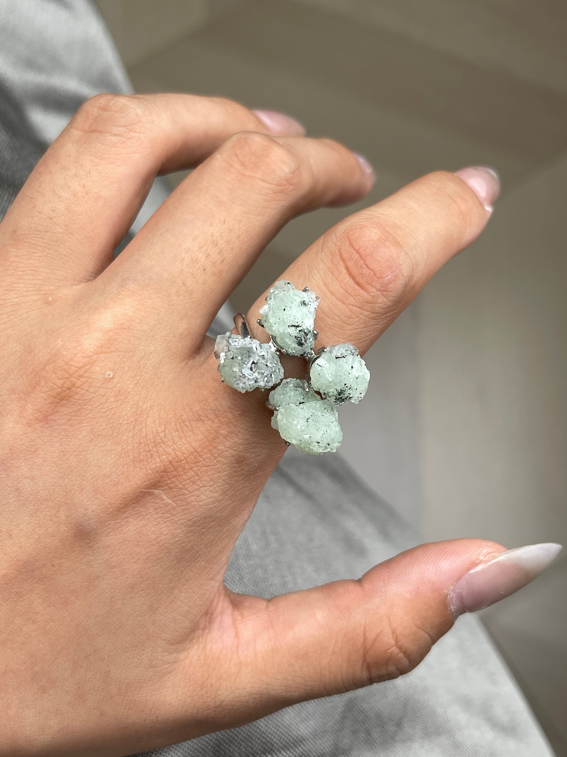 Close-up hand shot of Green Prehnite, Quartz and Magnetite Mineral Specimen Ring showing natural crystal details