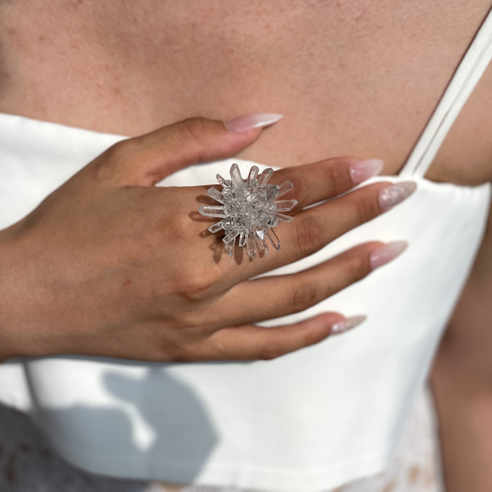 Close-up hand shot of Herkimer Diamond Quartz and Lemurian Quartz Flower Ring showing crystal details