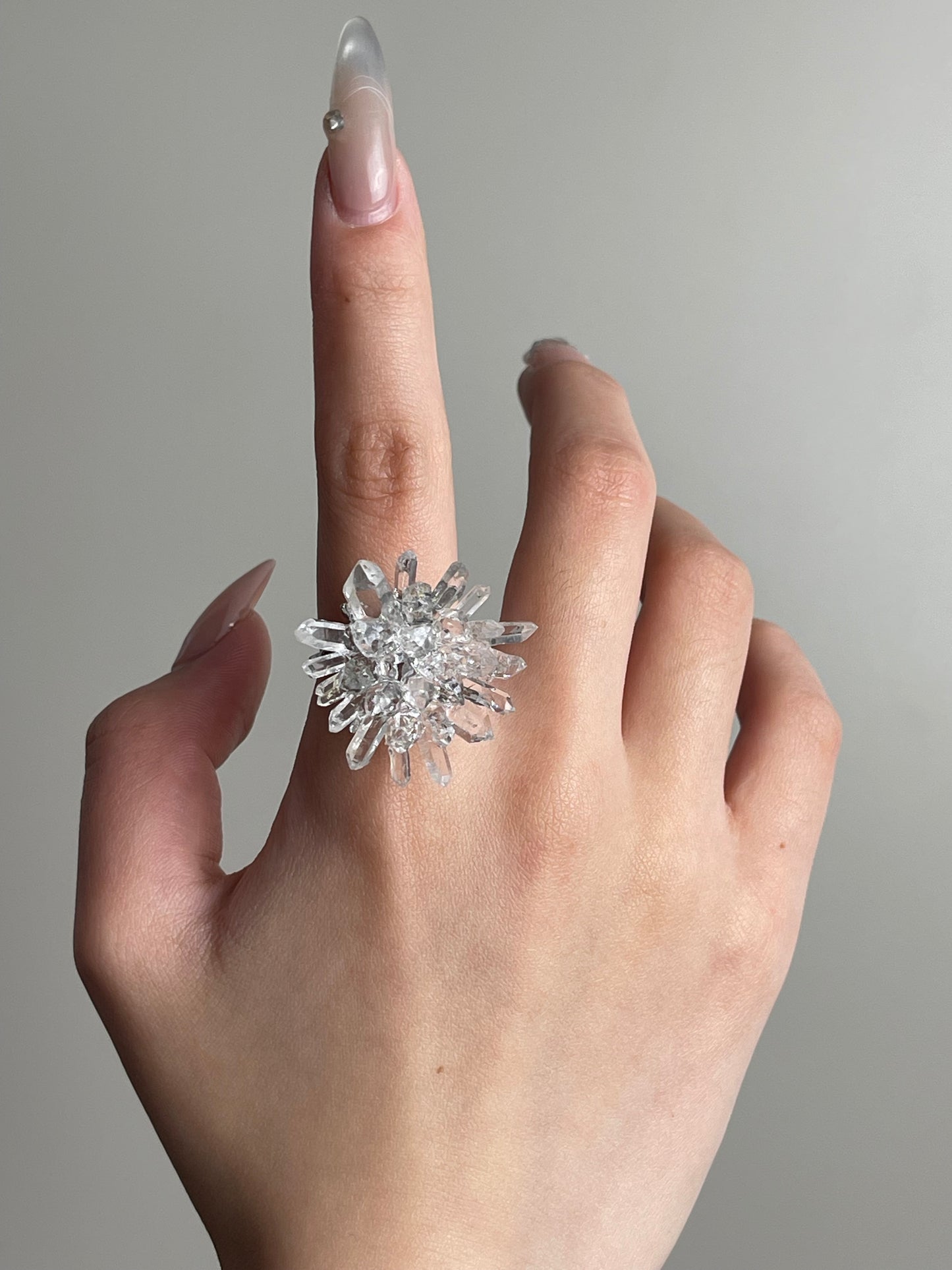 Herkimer Diamond Quartz and Lemurian Quartz Flower Ring worn on hand featuring a crystal flower design