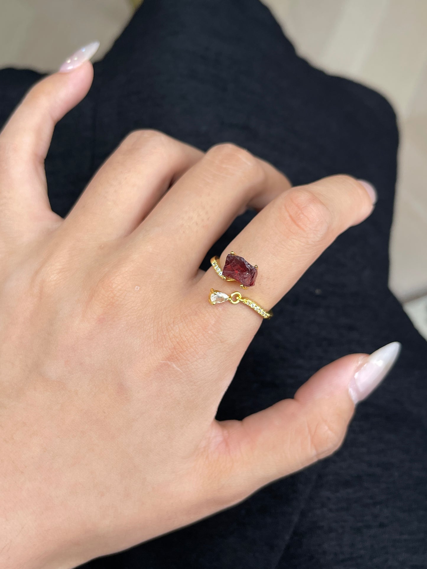 raw garnet ring on hand deep red crystal close up