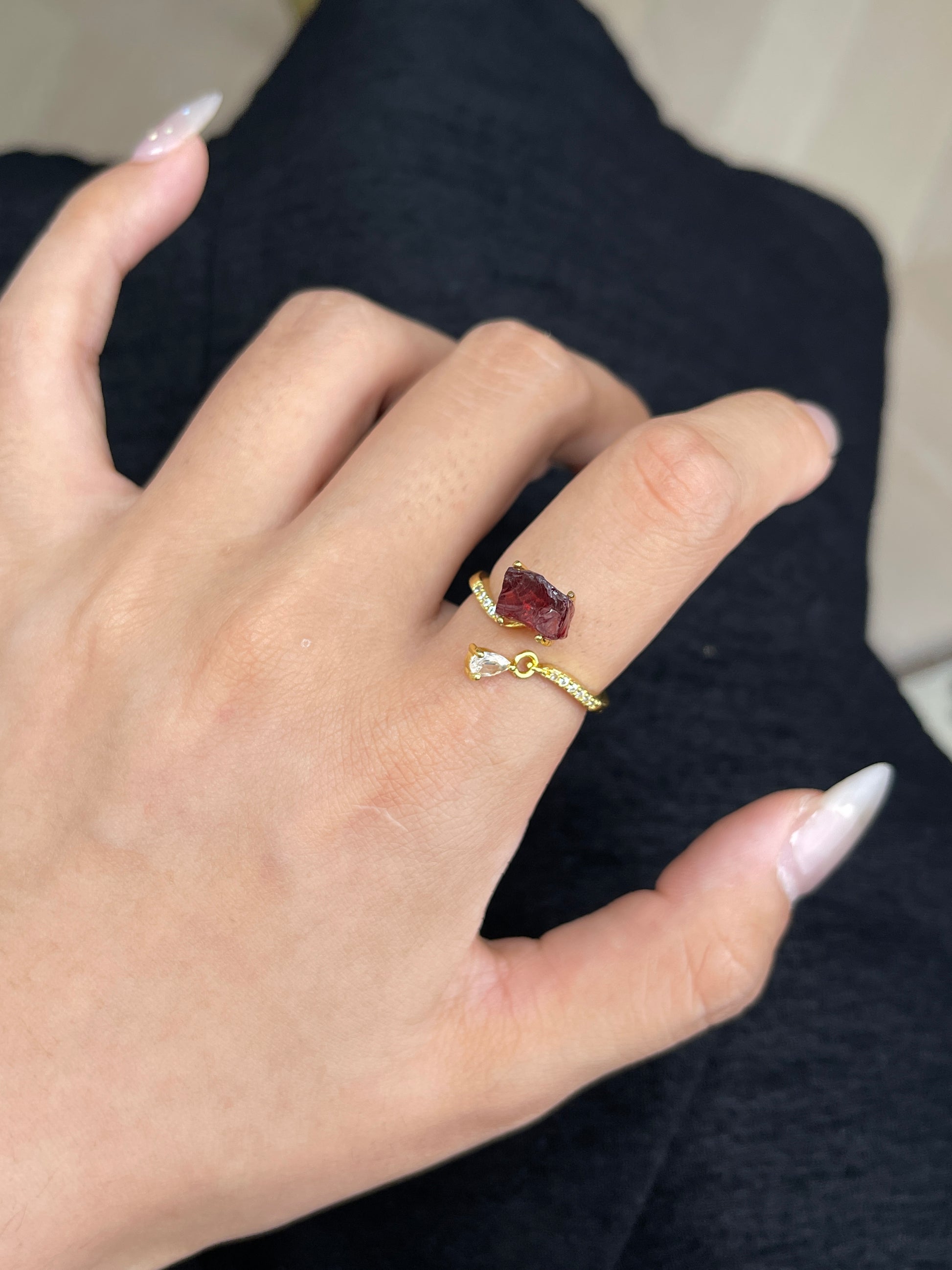 raw garnet ring on hand deep red crystal close up