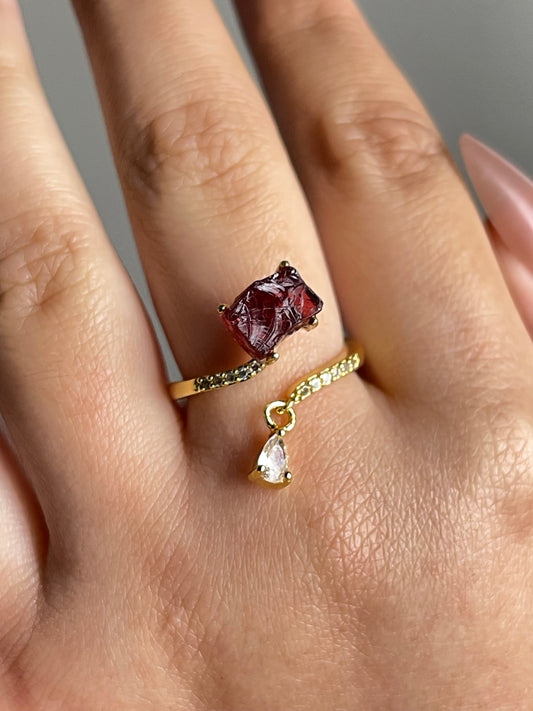 raw garnet ring on hand deep red crystal close up