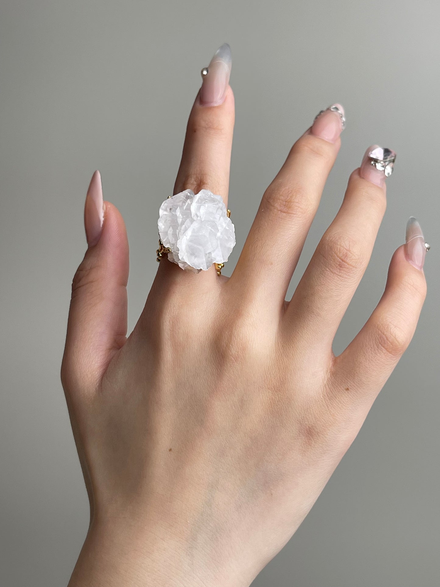 White Pagoda Calcite Ring worn on hand with natural layered calcite crystal