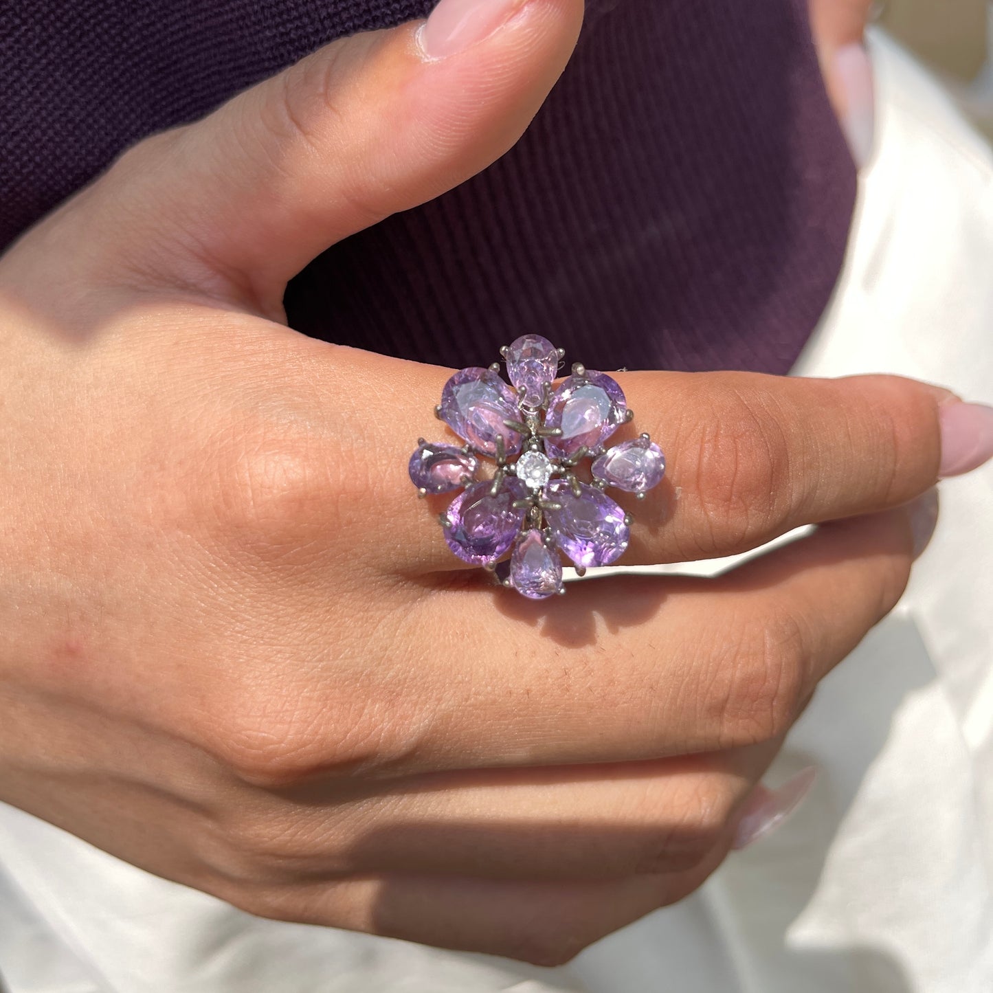 Pear-cut amethyst snowflake ring worn on hand, showing purple faceted amethyst stones in a floral snowflake design