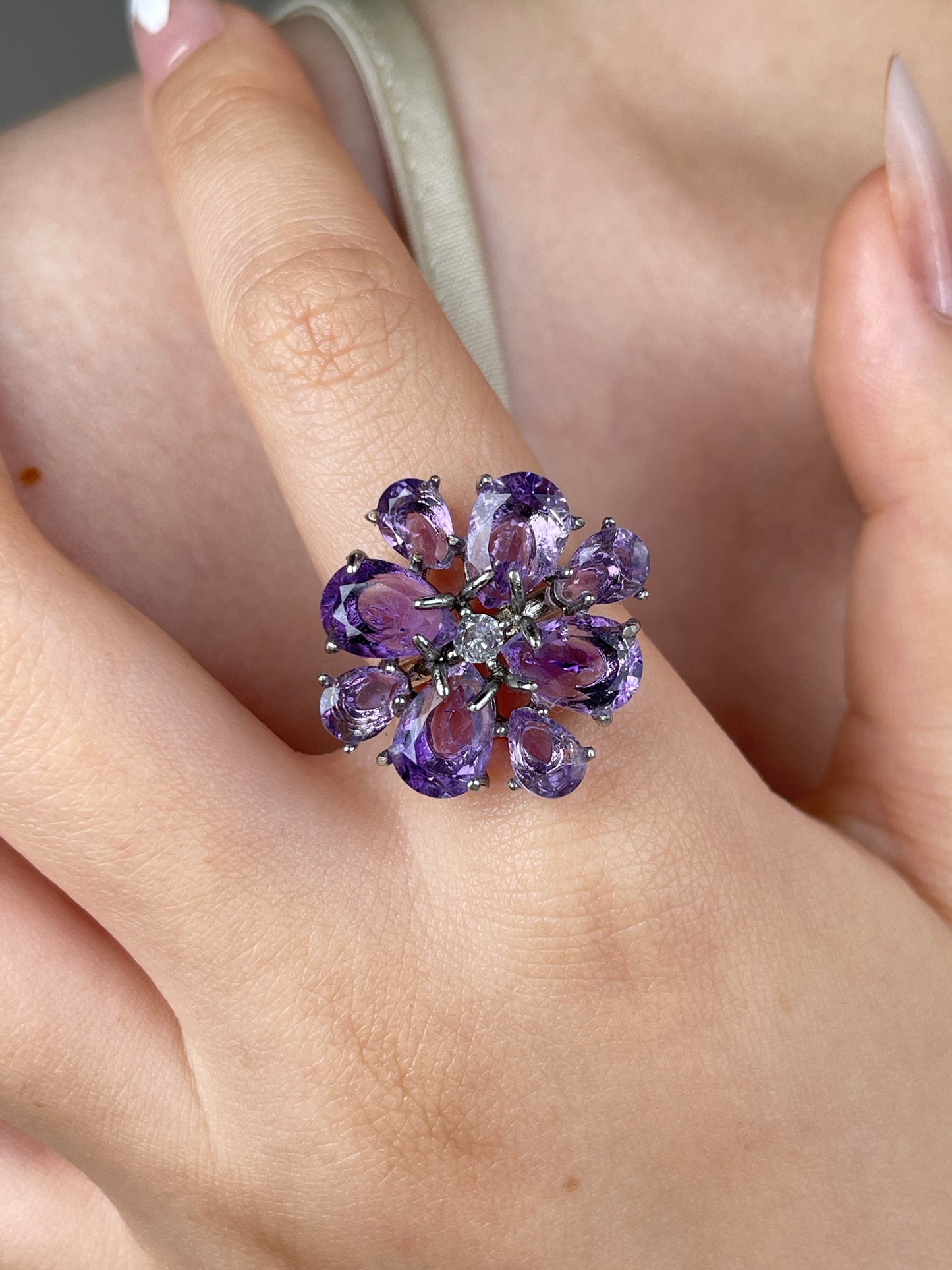 Pear-cut amethyst snowflake ring worn on hand, showing purple faceted amethyst stones in a floral snowflake design