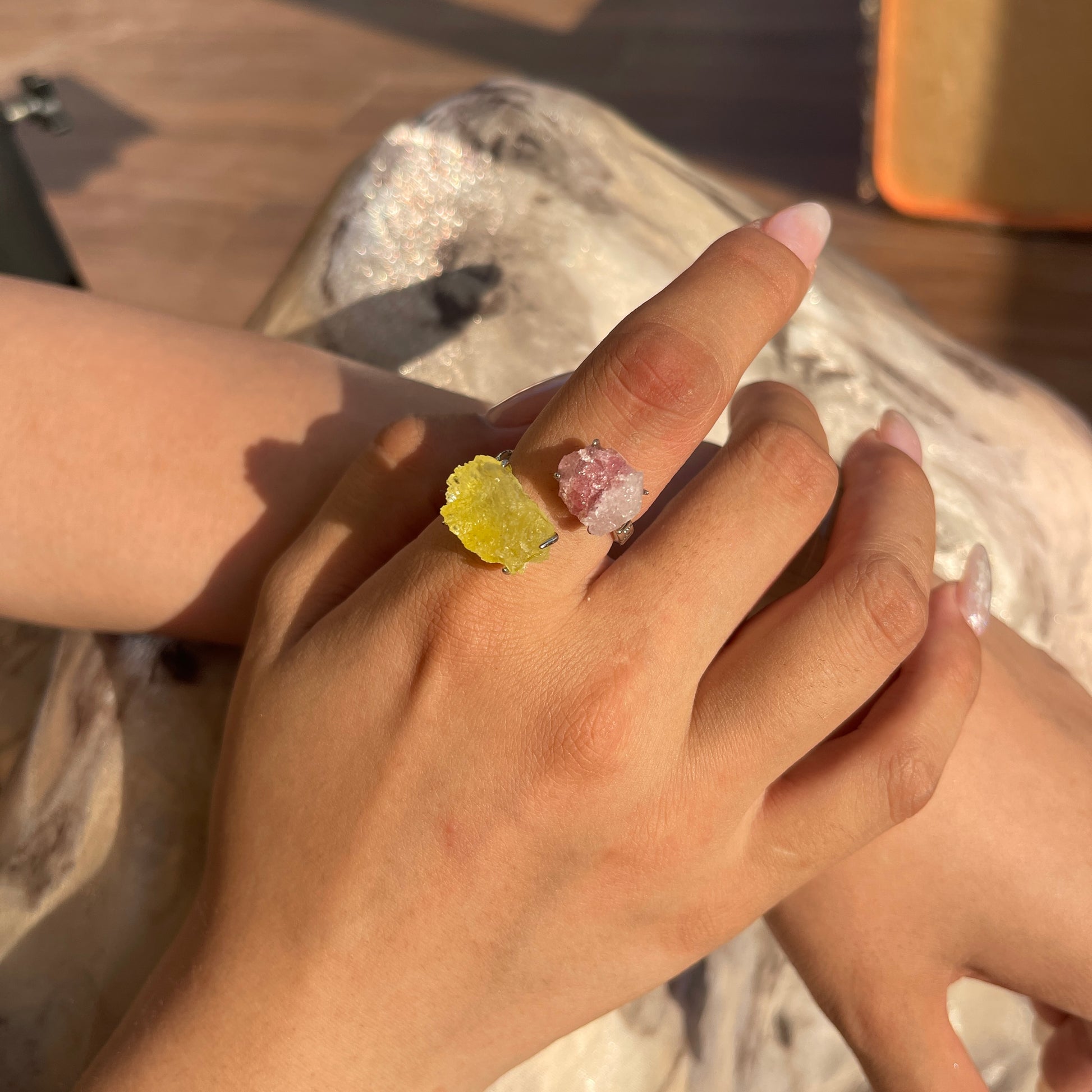 Pink Strawberry Quartz and yellow Brucite crystal ring worn on hand close up