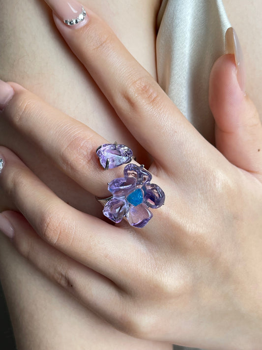 Close-up hand shot of polished Amethyst flower ring with Blue Apatite