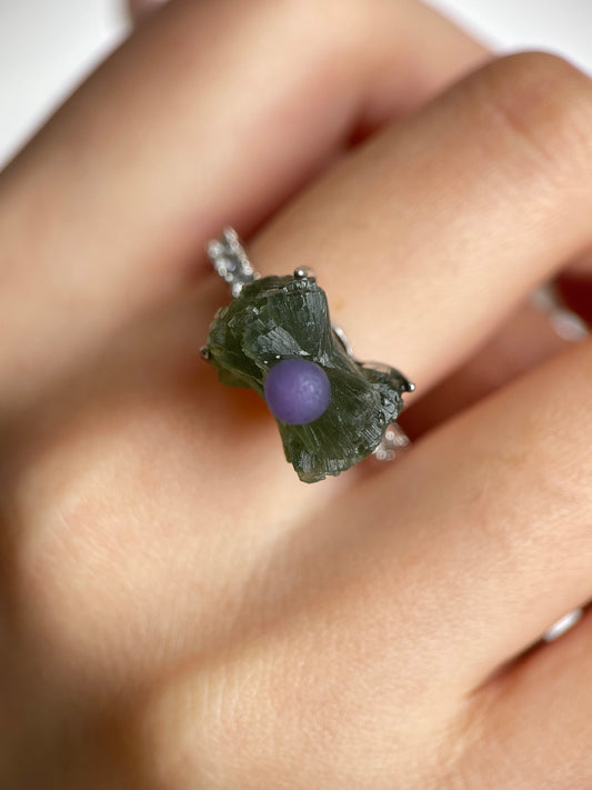 Close up of green prehnite and purple grape agate bow ring worn on hand