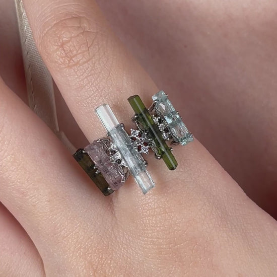 Video of a raw aquamarine, green tourmaline and morganite ring arranged like a tiny crystal landscape