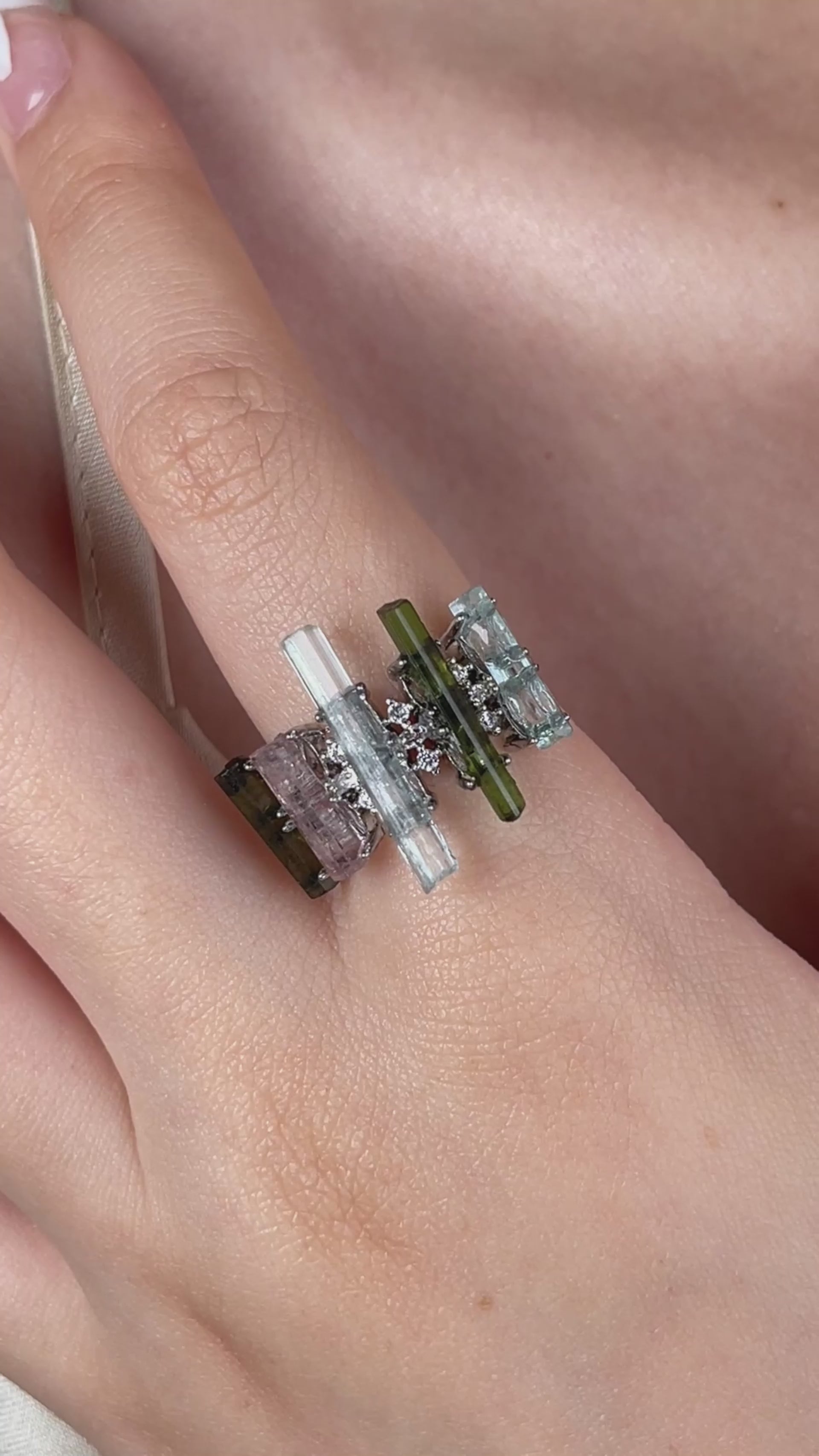 Video of a raw aquamarine, green tourmaline and morganite ring arranged like a tiny crystal landscape