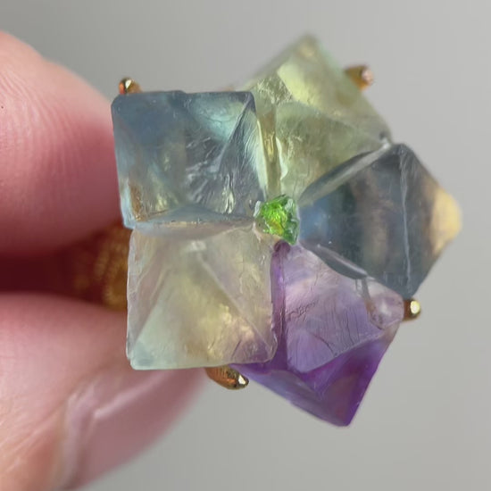 Video of octahedral fluorite flower ring with peridot center showing natural geometric crystal structure