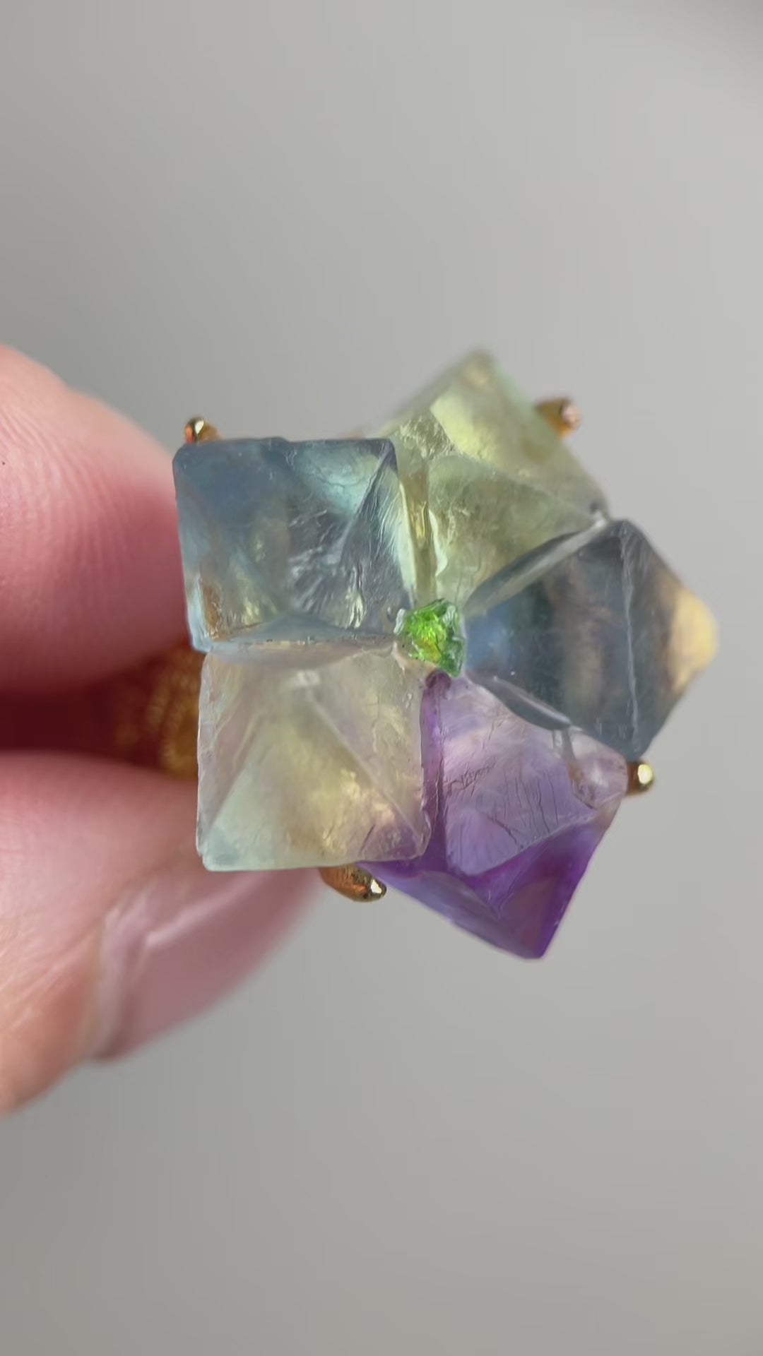 Video of octahedral fluorite flower ring with peridot center showing natural geometric crystal structure