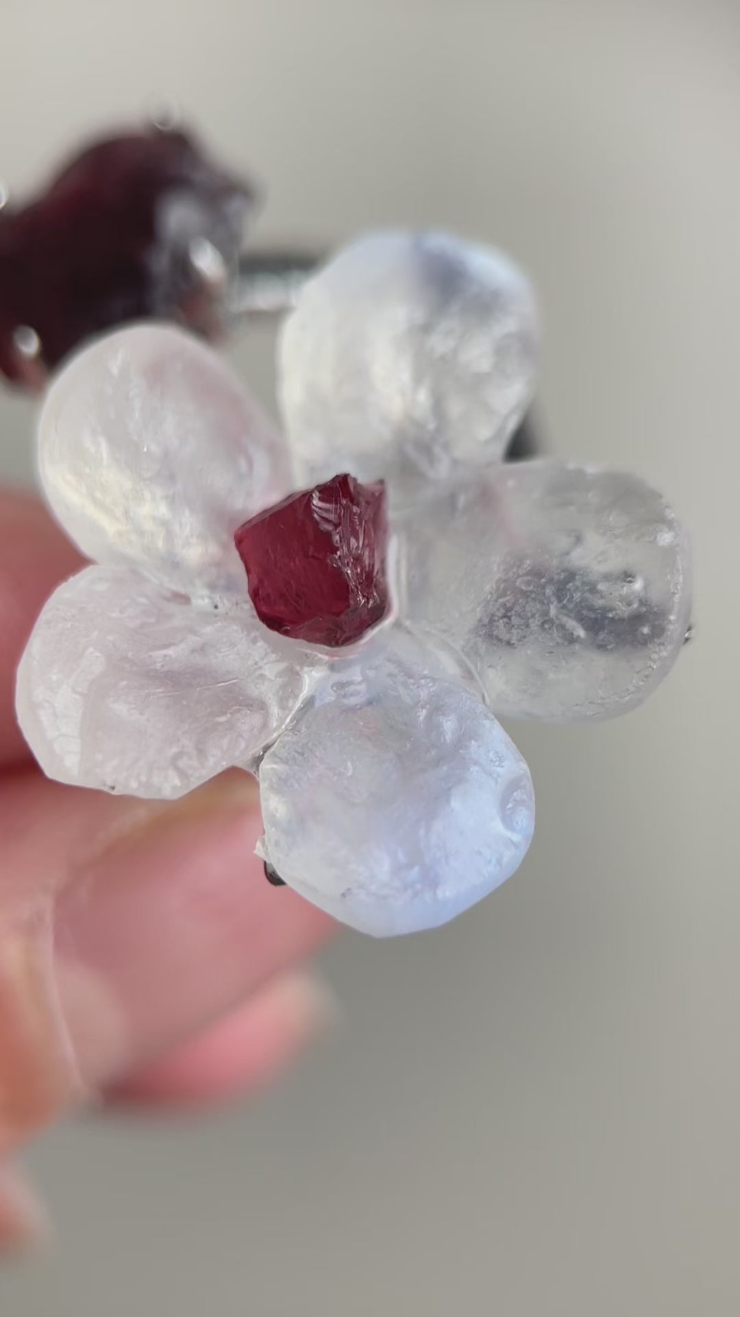 Video of Moonstone and Garnet crystal flower ring showing soft glow and red stone detail