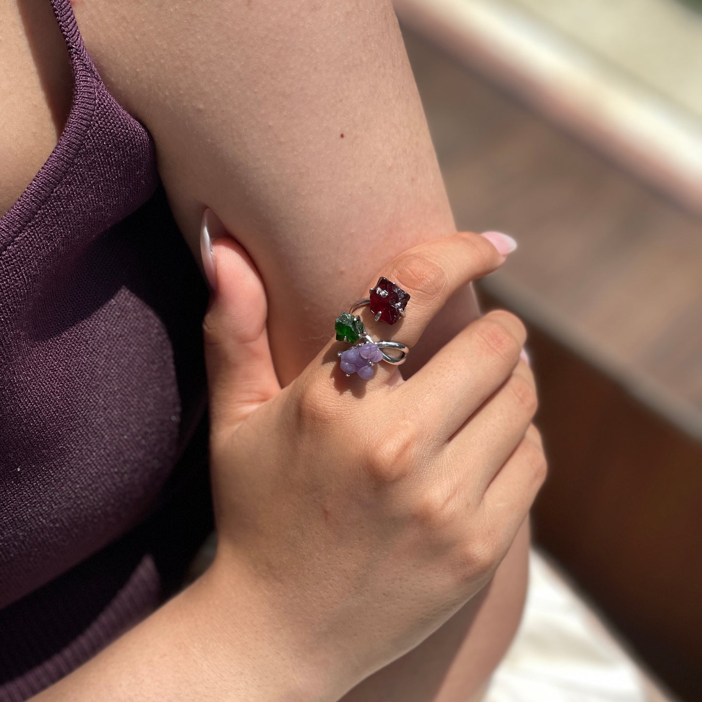 Close up of purple grape agate, chrome diopside and raw garnet ring worn on hand