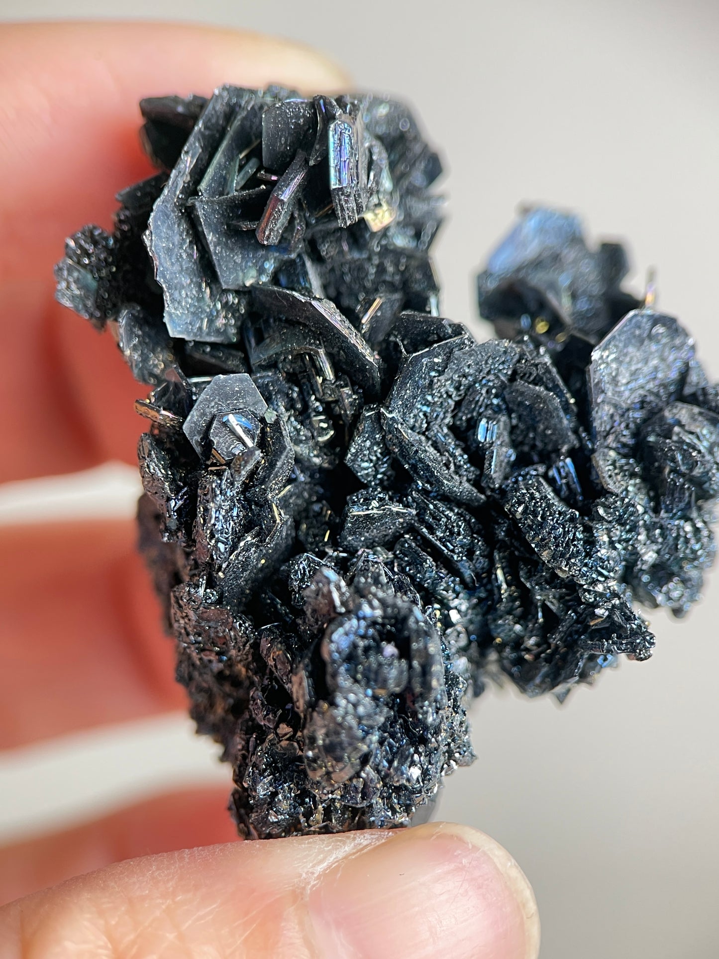Close-up detail of Rainbow Carborundum silicon carbide crystals with metallic black texture and rainbow iridescent flashes.