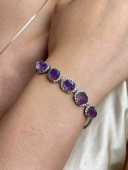 Close-up of raw amethyst bracelet worn on wrist