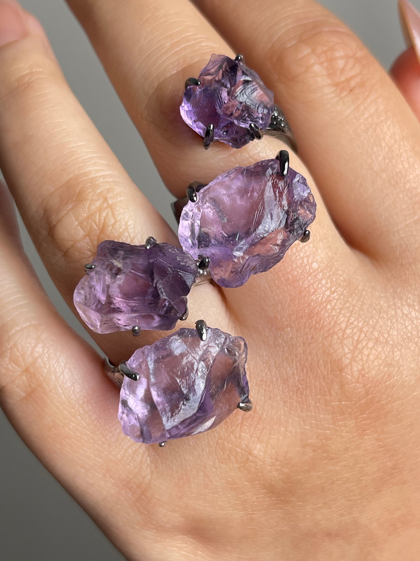 Close-up of raw amethyst ring showing natural crystal texture on hand