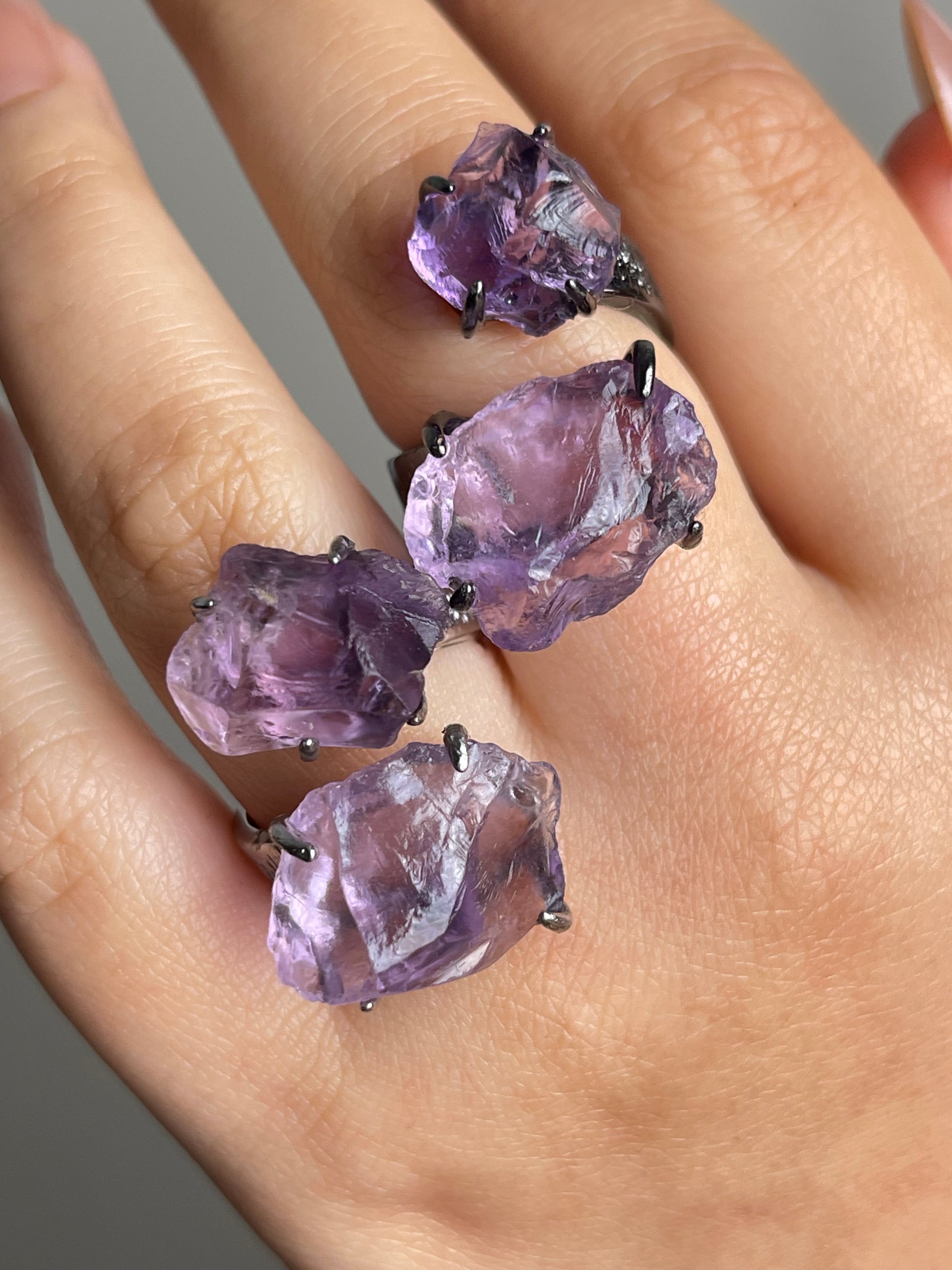 Close-up of raw amethyst ring showing natural crystal texture on hand