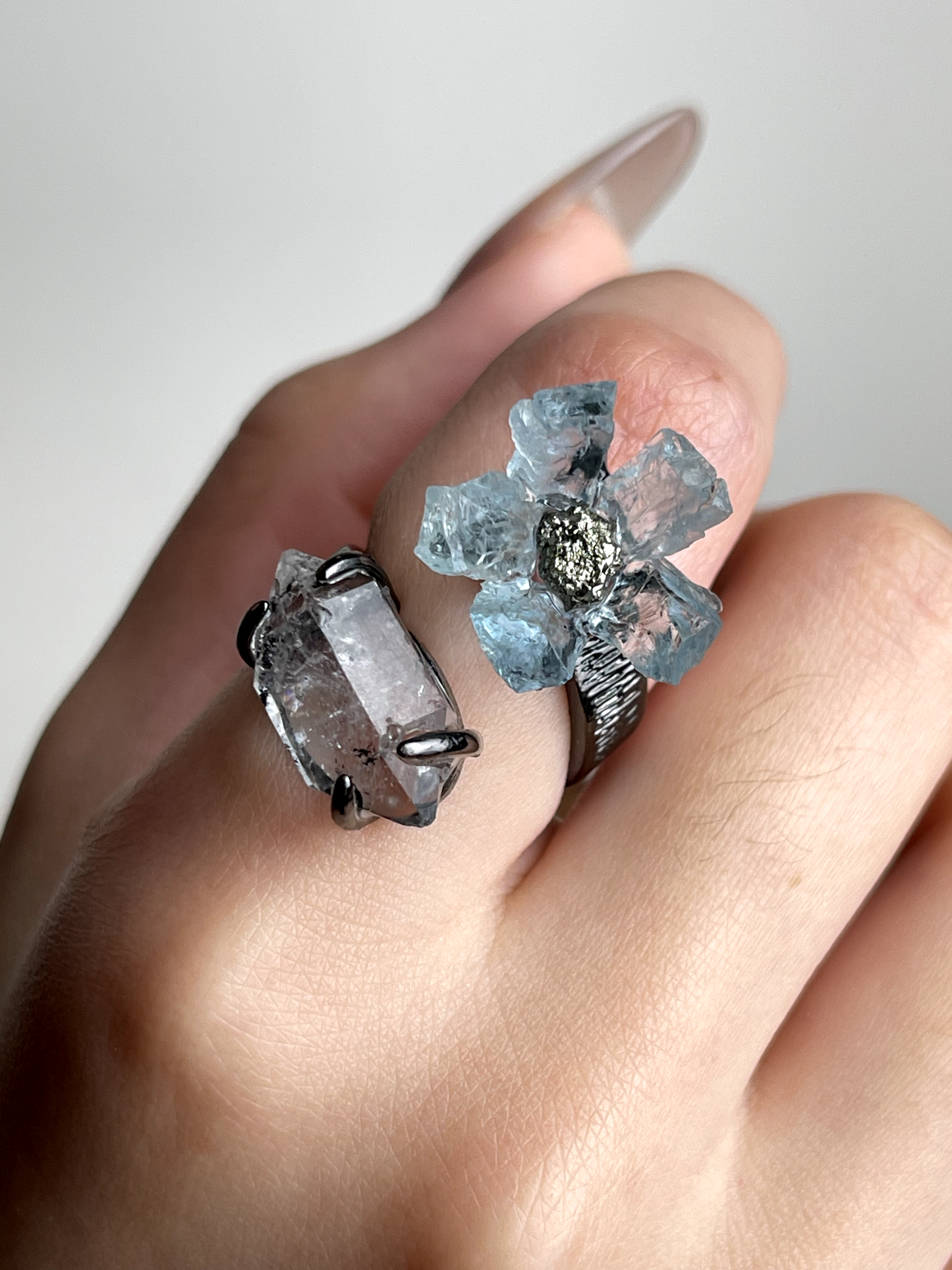 Close-up hand shot of raw Aquamarine flower ring with Hakima Diamond Quartz