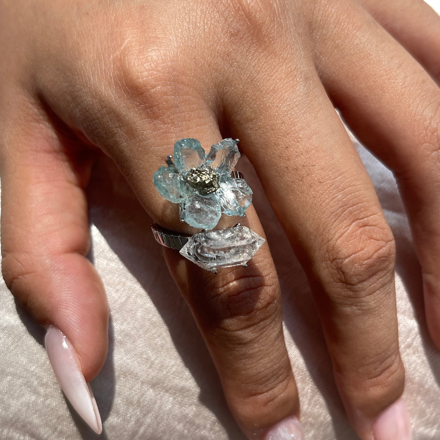 Close-up hand shot of raw Aquamarine flower ring with Hakima Diamond Quartz