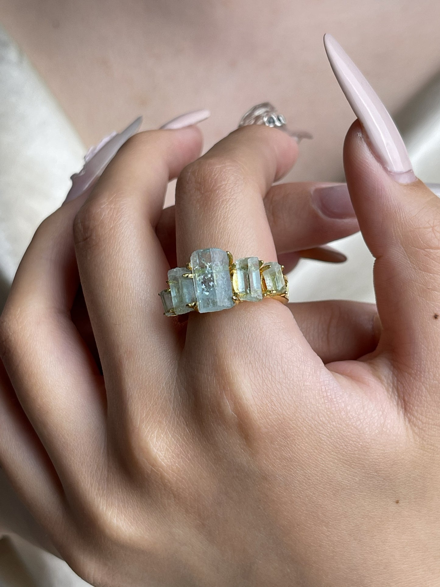 Hand wearing raw Aquamarine hexagonal column band ring