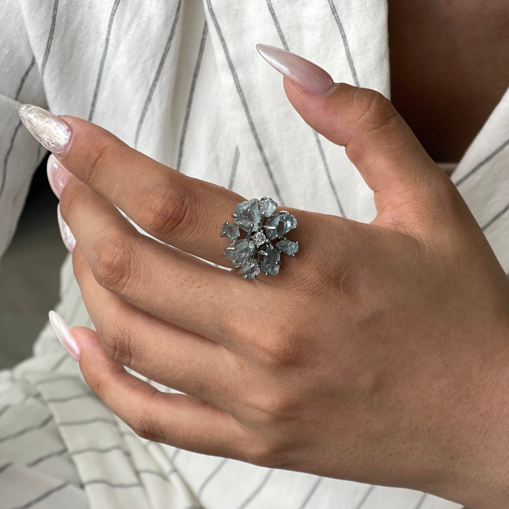 Raw Brazilian aquamarine snowflake ring worn on hand, showing natural icy blue crystal texture