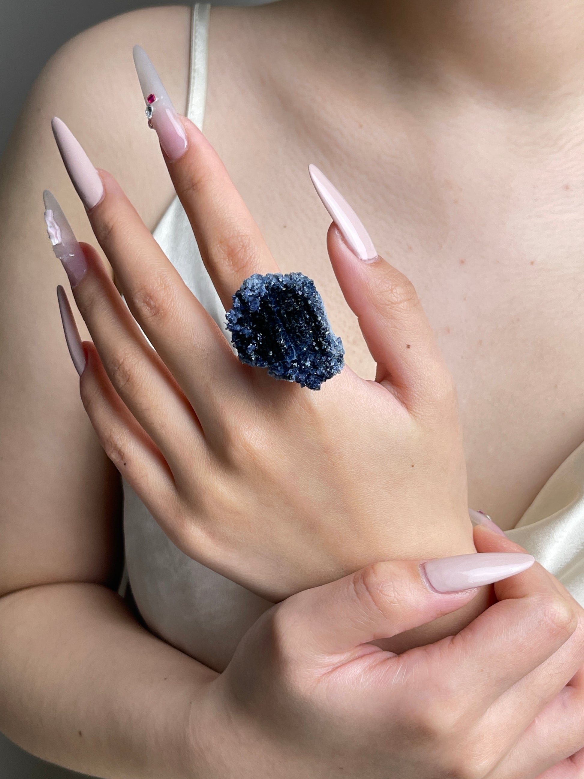 Raw Blue Sapphire crystal cluster ring worn on hand.