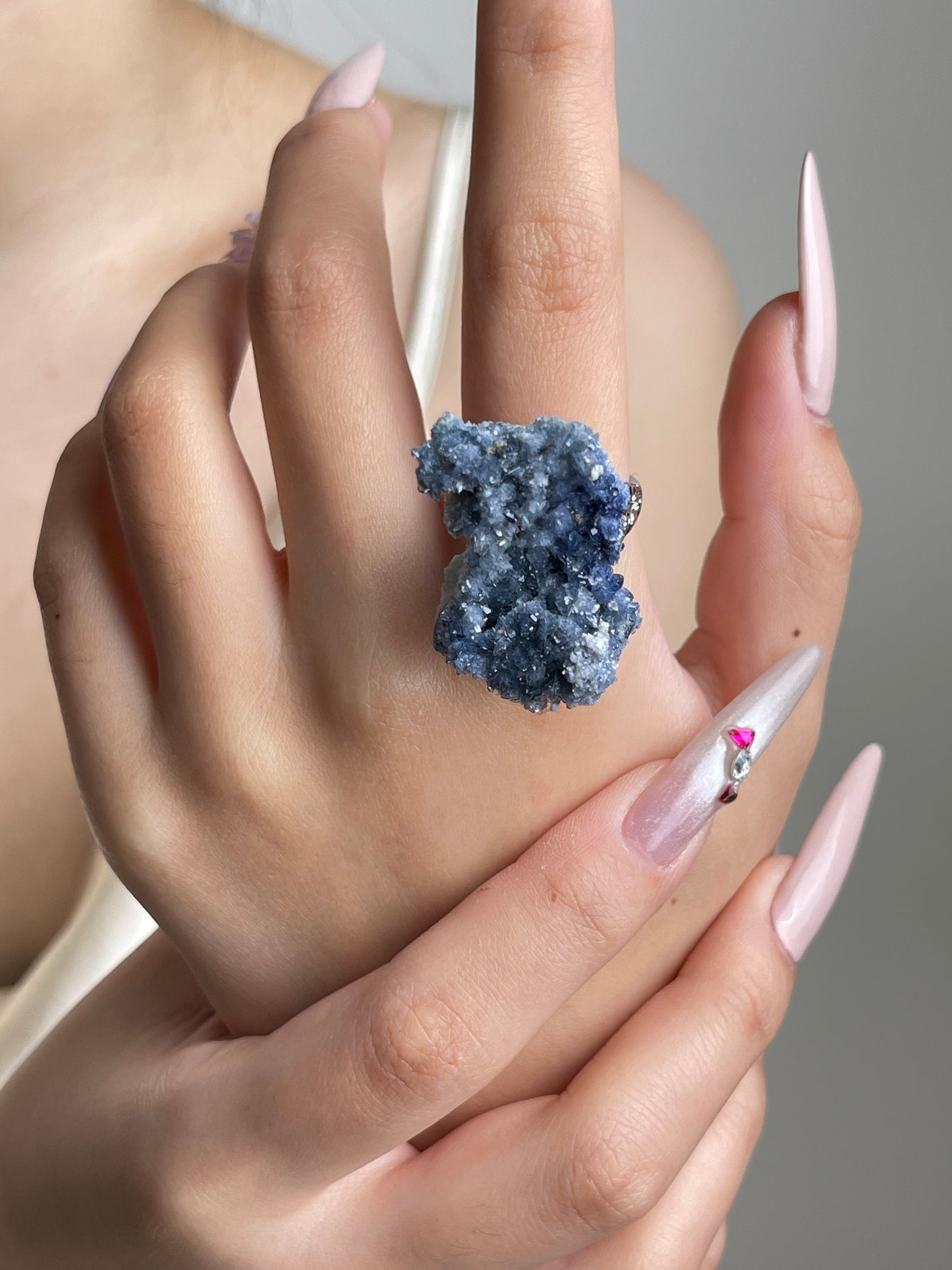 Raw Blue Sapphire crystal ring worn on hand.
