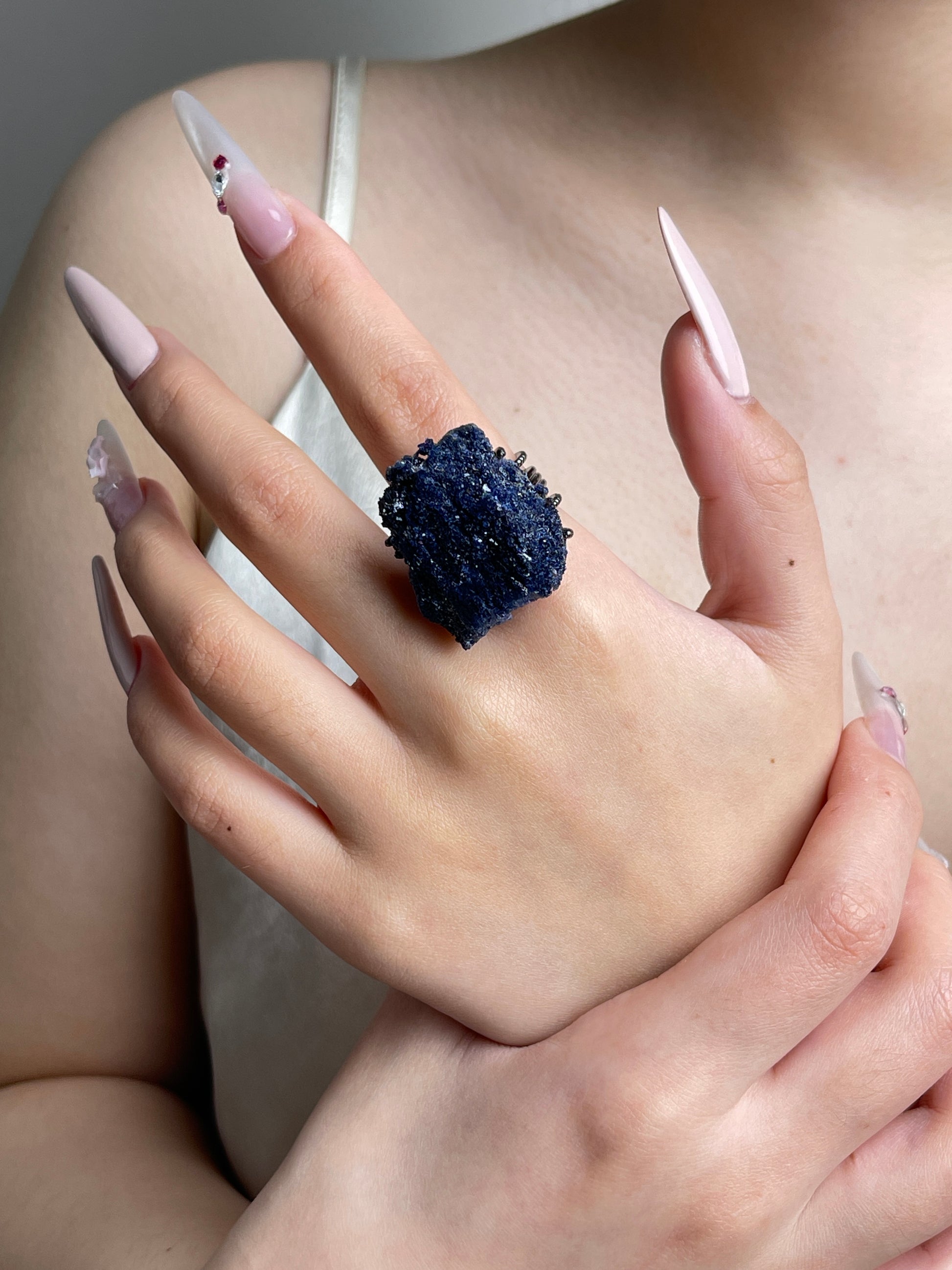 Raw Blue Sapphire mineral specimen ring worn on hand.