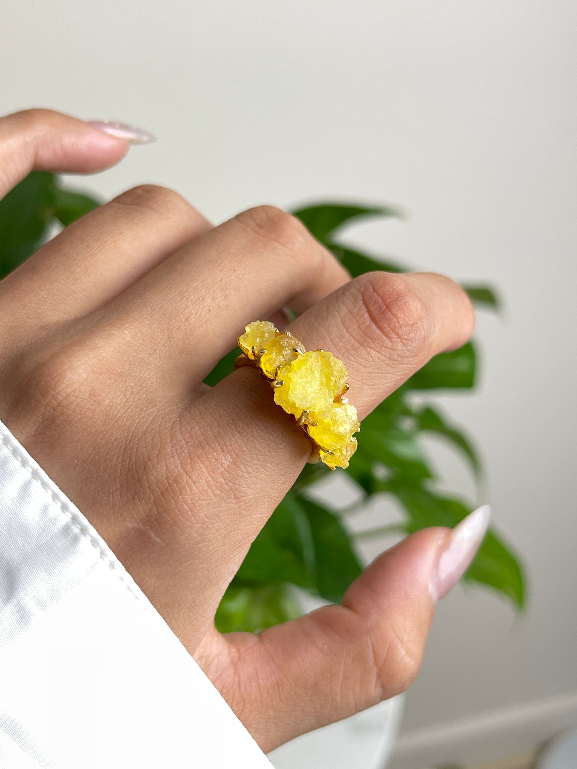 raw brucite crystal ring close up on hand yellow mineral