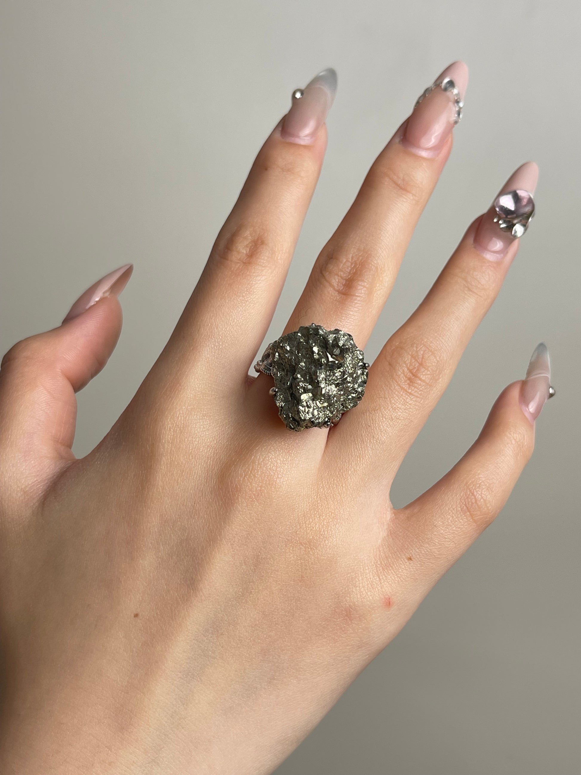 Raw chalcopyrite mineral specimen ring worn on hand