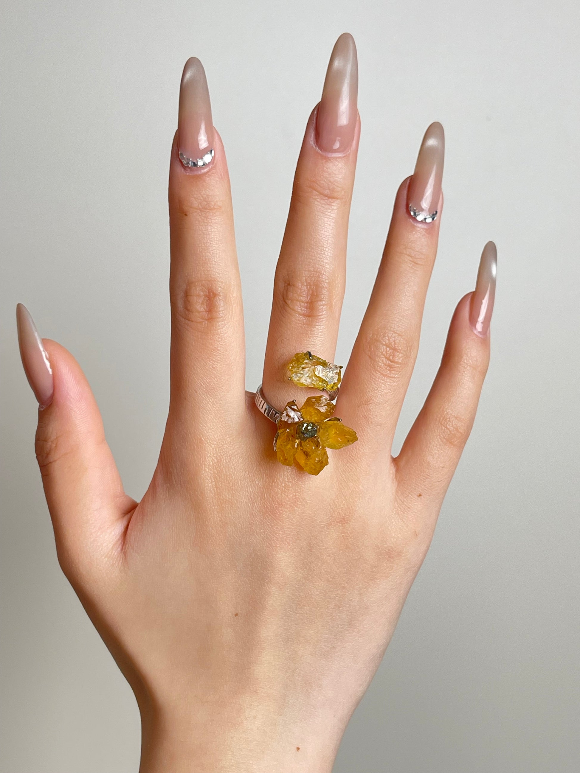 Hand shot of raw citrine flower ring with chalcopyrite center