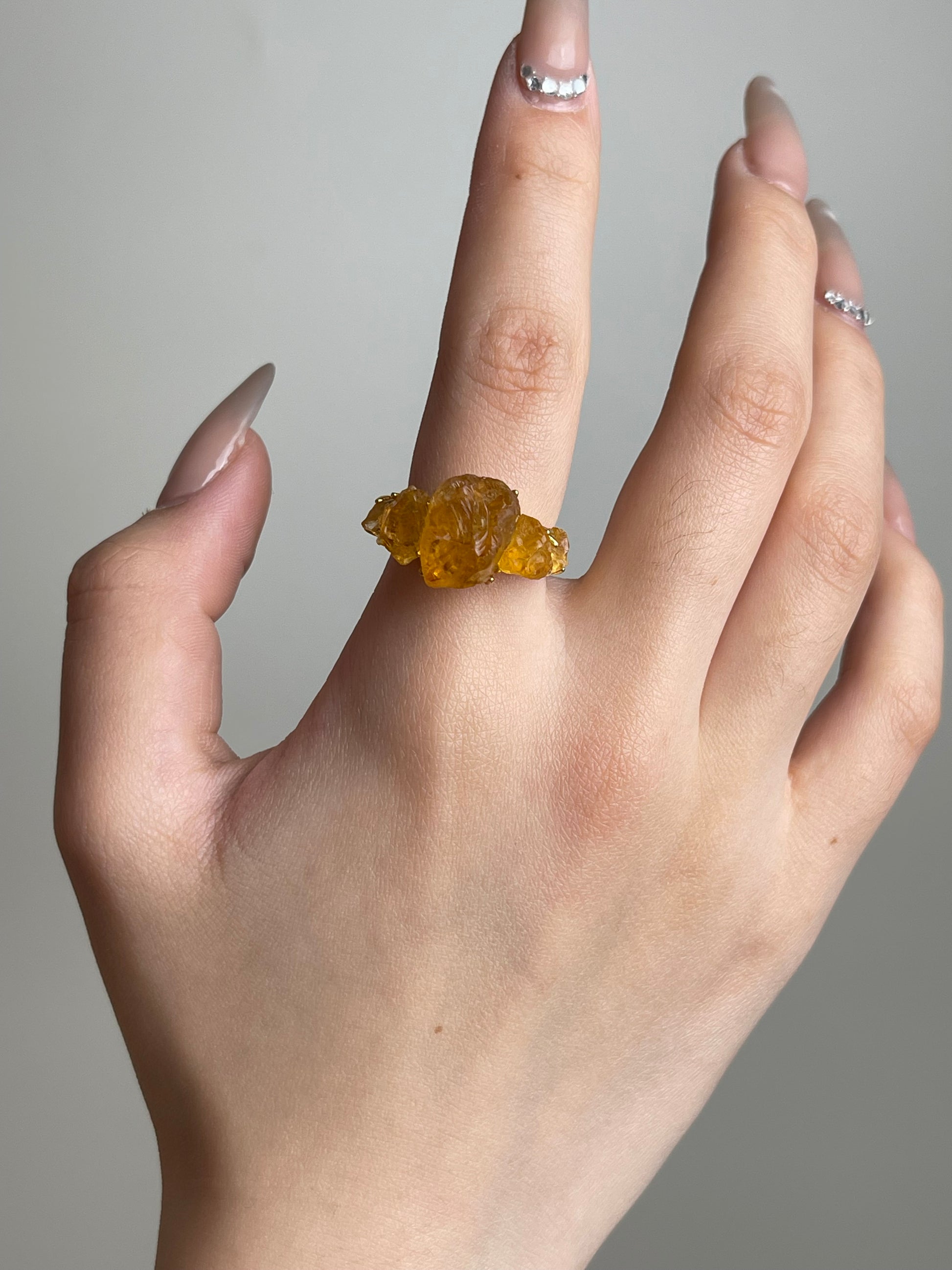 Raw citrine crystal ring worn on hand
