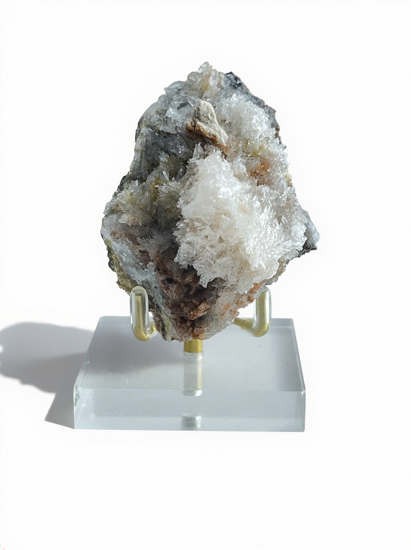 Raw Creedite cluster mineral specimen on matrix with display stand