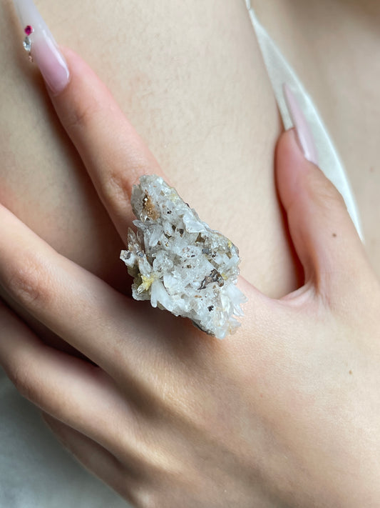 Close-up hand view of a raw Creedite crystal cluster ring.